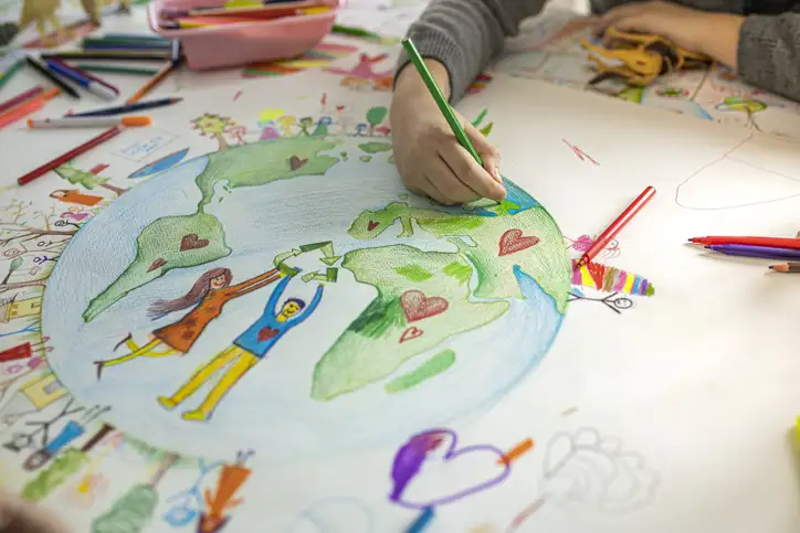 child's hands while drawing Ecofriendly theme on paper.